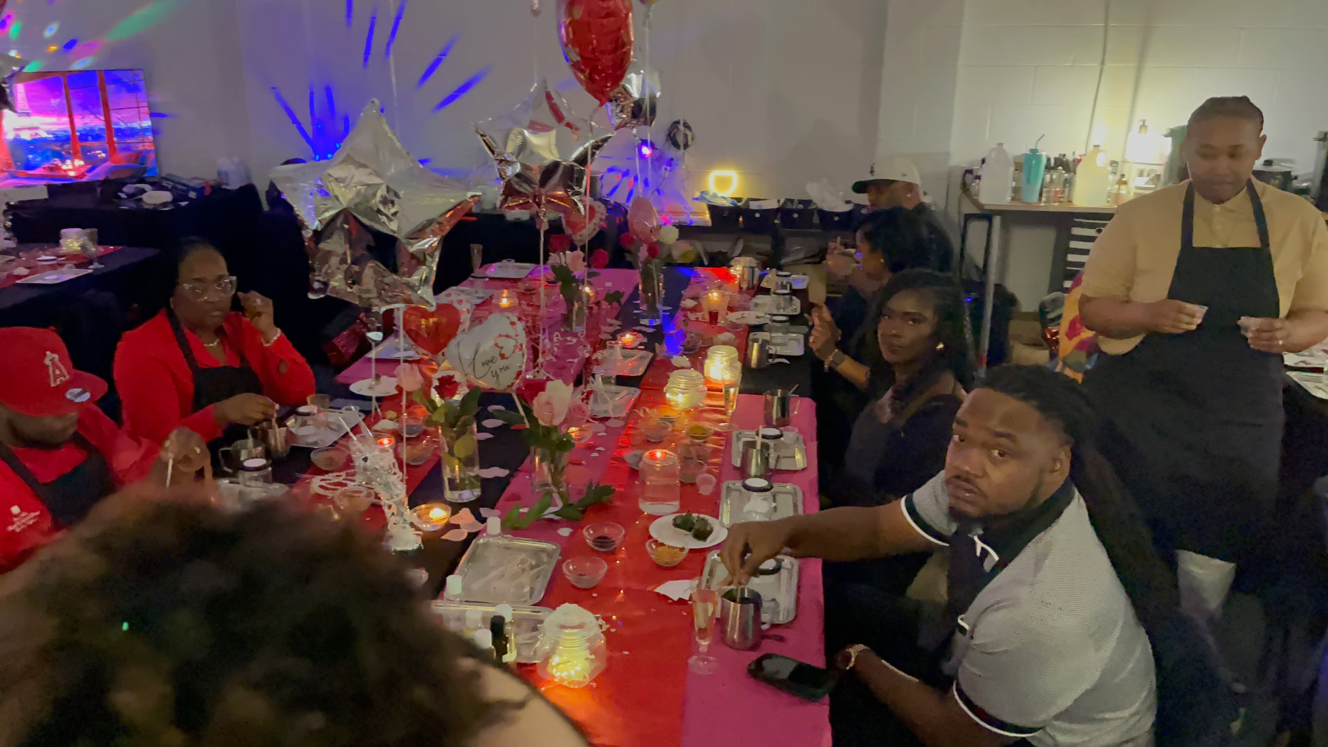 Valentine event with guests seated at a red and pink styled candle bar table