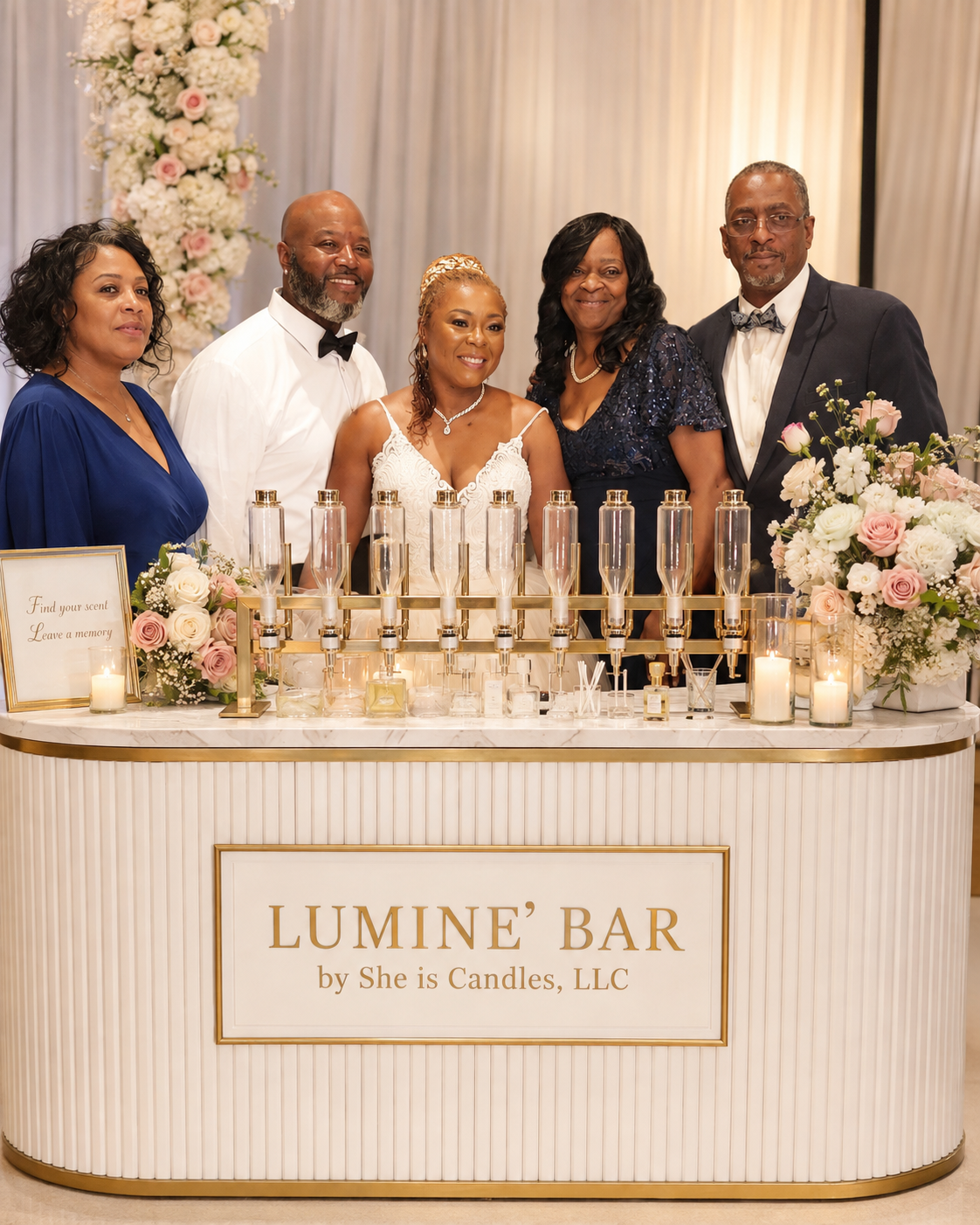 Wedding party gathered around the Luminé Bar wedding perfume bar at a reception