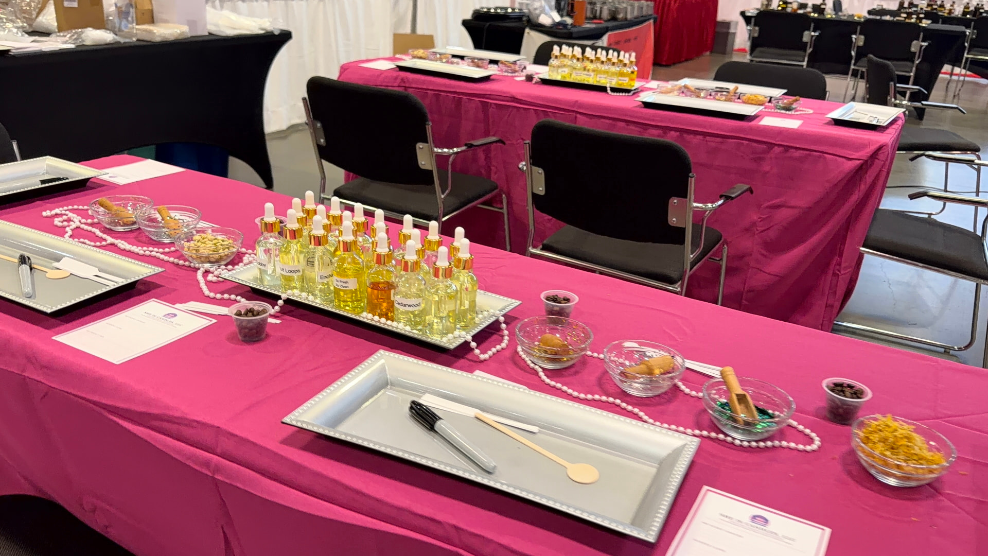 Fuchsia linen tables set with fragrance oils, pearls and botanicals