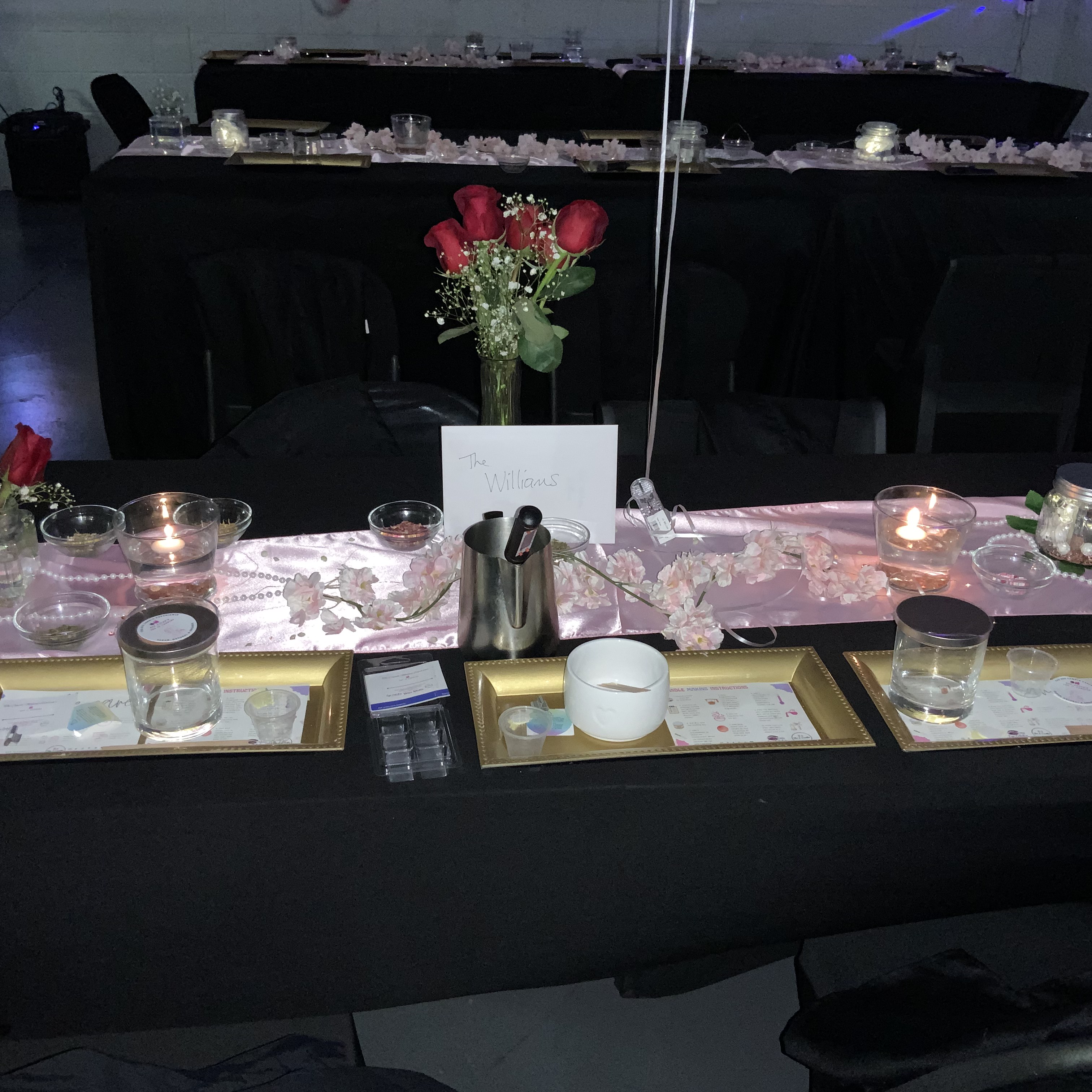 Long candlelit table styled for an evening fragrance and candle experience